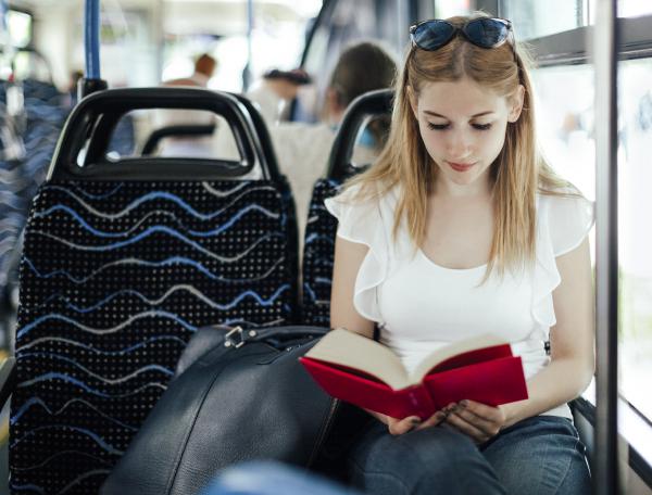 Student reading on bus