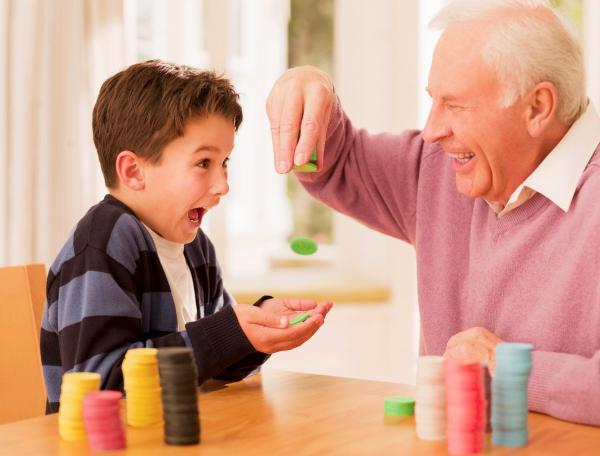 Grandfather and grandson play with colored tokens