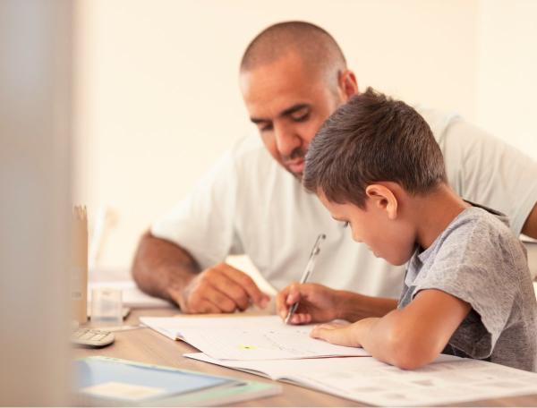 Father and son with pen in hand looking at note pad