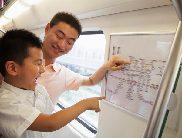 Father and son looking at a railway station map