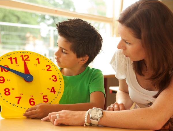 Mother and son looking at a toy analog clock 